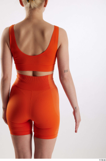 Unaisa  1 arm back view dressed flexing orange sports…